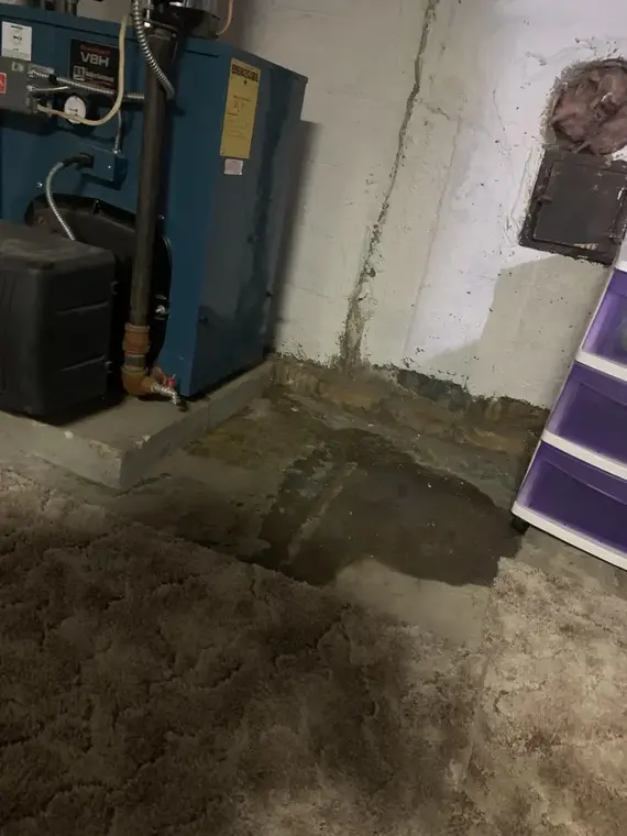 Water on a cellar floor beside a boiler in Queens